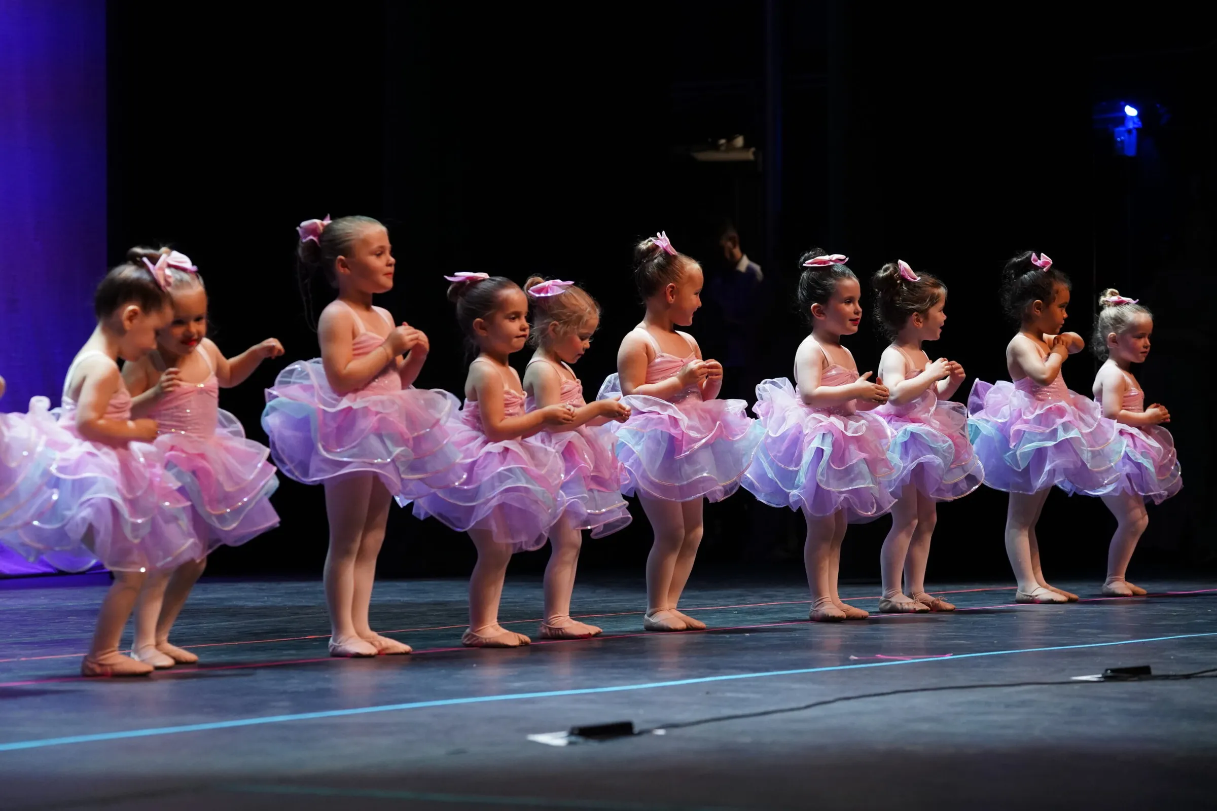 Young KICK dancers in lilac tutus performing on stage